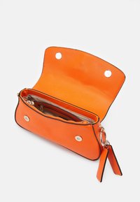 Oranje leren handtas met structuur, twee magnetische drukkers, binnenste ritsvak en contrasterende zwarte afwerking.