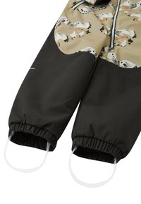 Barns svart- och beige snowsuit med benmönster av måsar, elastiska muddar och fästa transparenta fotremmar.