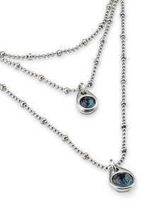 Collier en argent à plusieurs mèches, présentant des perles rondes et deux pendentifs en forme de larme, chacun ayant une pierre précieuse bleue au centre.
