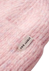 Cappello lavorato a maglia rosa con una texture a coste e striature visibili. Presenta un'etichetta in tessuto bianco con la scritta "STREET ONE" in caratteri neri sul lato.