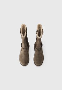 Brune mockaskinn mid-kalv støvler med faux fur fôr, flate såler og sidelåser. Har sydd detaljer og en glatt tekstur.