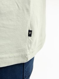 Lichtgroene katoenen T-shirt met een rechte snit, logo label aan de zijnaad en eenvoudige zoomstiksels. Geen opvallende patronen of accenten.
