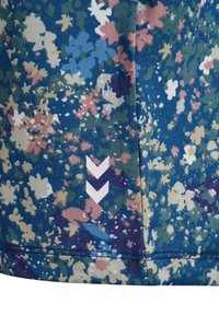 Blåt stof med lyserødt, gult og hvidt blomstermønster, med to hvide nedadpegende Chevron-symboler nær den syede søm.