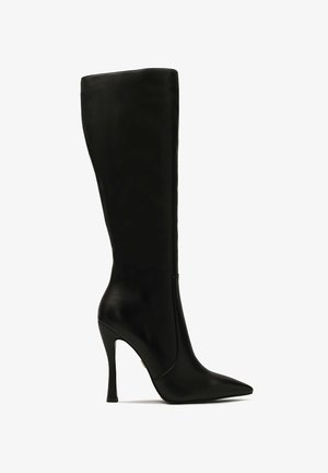 Černá kožená vysoká bota až po kolena s špičatou špičkou a úzkým stiletto podpatkem, vyznačující se hladkou texturou a bezproblémovým designem.