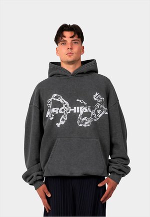 Dark gray oversized hoodie with a front pocket. Features white graphic print and a drawstring hood. Sleeves are loose-fitting.