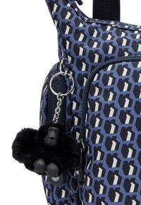 Borsa blu con motivo geometrico, decorata con un portachiavi a forma di scimmia nera. Realizzata in materiale resistente, con scomparti con cerniera.