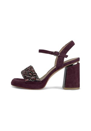 Sandalo con tacco a blocco in suede prugna, dotato di cinturino alla caviglia e fascia frontale decorata con gemme rosso scuro.