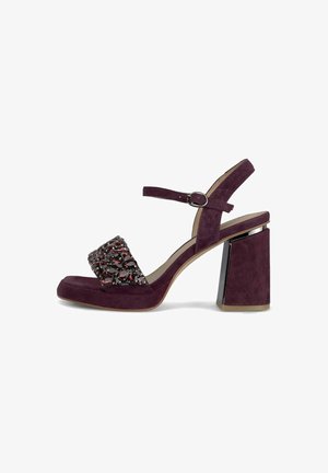 Pruimen kleur suède blokhak sandalen met enkelband en een voorkant band versierd met donkerrode edelstenen.