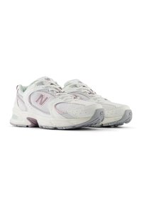 Baskets de sport blanches avec une tige en mesh, des accents lavande et des détails réfléchissants. Semelles épaisses avec une semelle extérieure grise texturée pour une meilleure adhérence.