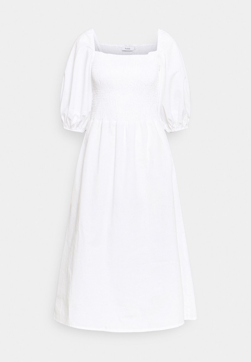 Robe midi blanche avec encolure carrée smockée, manches bouffantes au niveau des coudes et jupe évasée sur fond uni.