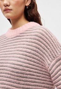 Pulover tricotat cu dungi orizontale roz și gri, cu decolteu rotund cu margine striată și textură moale. Mâneci scurte cu croială lejeră.