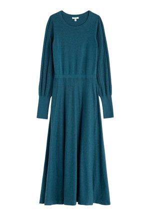 Tīrkīza adīta kleita ar garām pūkainām piedurknēm, kas ir ar ribota tekstūra. Pielāgota vidukļa daļa un izpletusies svārku daļa. Apļa izgriezums un garums līdz vidus telpām.