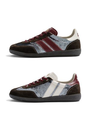 Deux baskets basses en suède marron foncé, avec des panneaux argentés à sequins, des rayures grenat et blanches, des lacets grenat et des semelles noires texturées.