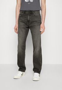 Jeans din denim gri, cu un design cu picioare drepte, textură îmbătrânită, cinci buzunare și fermoar cu buton. Asortați cu adidași albi.