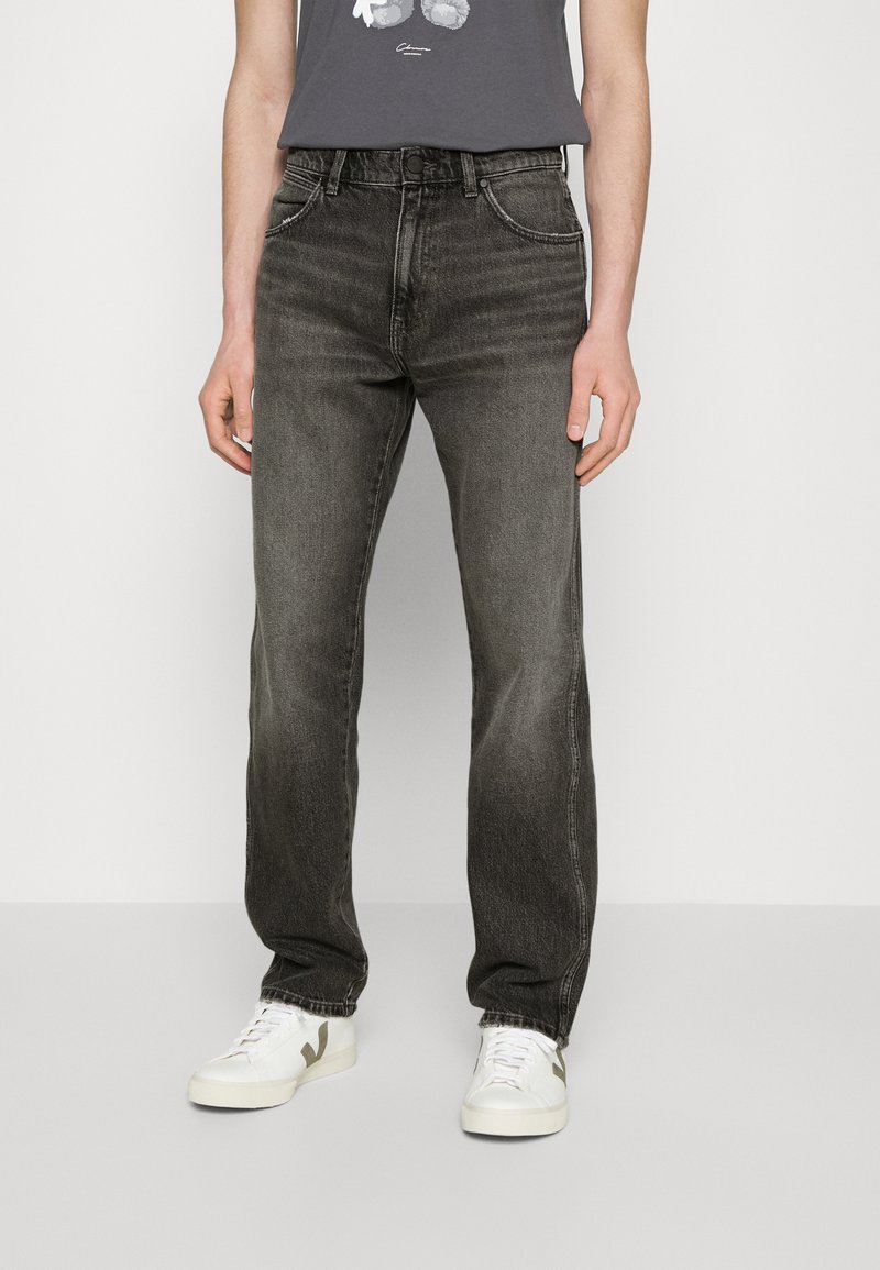 Jeans din denim gri, cu un design cu picioare drepte, textură îmbătrânită, cinci buzunare și fermoar cu buton. Asortați cu adidași albi.