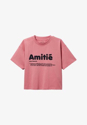 T-shirt court rose à manches courtes avec un texte noir en français définissant "Amitié" (friendship) imprimé à l'avant.