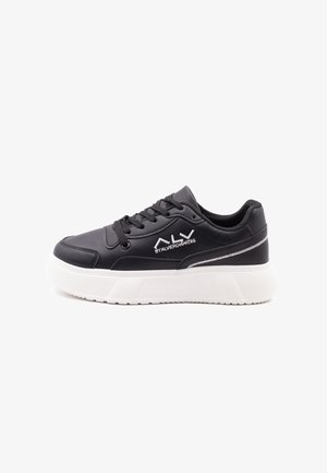 Sneaker nera realizzata in materiale sintetico, con suola piatta in gomma bianca, chiusura con lacci e dettaglio del logo ricamato in bianco sul lato.