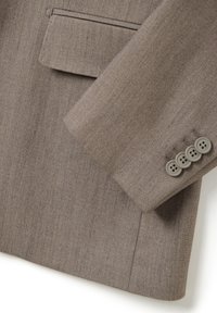 Blazer marrone su misura con una texture liscia, revers affilato e quattro bottoni grigi sui polsini. Include un delicato dettaglio della tasca.