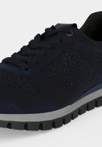Baskets bleu foncé avec lacets noirs, détails imprimés animal texturés et semelle épaisse grise avec des crampons profonds.