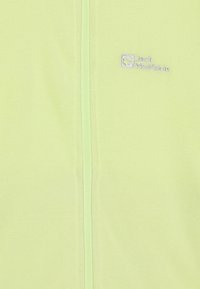 Veste en polaire vert clair avec fermeture éclair complète, arborant un logo brodé sur la poitrine gauche et un tissu texturé pour le confort.