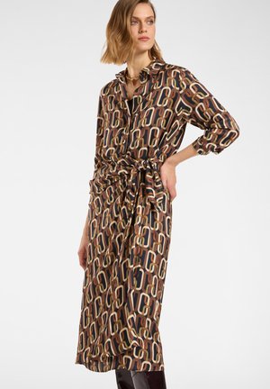 Vestido de manga larga con cuello que presenta un patrón de eslabones en tonos marrón, beige y verde olivo. El detalle de la cintura anudada aporta definición a la silueta.