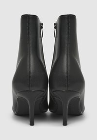 Stivaletti neri con tacco alto in pelle liscia, zip sul retro e tacchi a stiletto sottili. Presentano una punta chiusa e un design elegante.