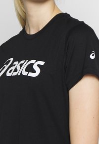 Schwarzes T-Shirt mit kurzen Ärmeln aus Baumwolle, mit einem großen weißen "asics"-Logo auf der Vorderseite und einem kleinen Logo auf dem linken Ärmel.