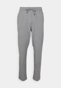 Šedé tepláky s elastickým páskem, šňůrkou a zužujícími se nohavicemi. Měkká textura s hladkým povrchem bez viditelných vzorů nebo ozdob.