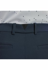 Marinblå byxor i ett slätt tyg, med standard midjeband, två bakfickor och en centralt sydd detalj.