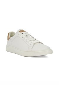 White leather sneaker with a smooth texture, round toe, lace-up design, and tan suede accent on the heel. Rubber sole with textured grip.