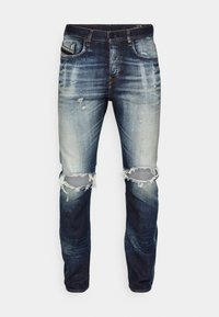 Slim-fit jeans i mörkblå denim med ljusa blekningar, slitna detaljer och rivna knän. Har klassiska fickor och metallknappsstängning.