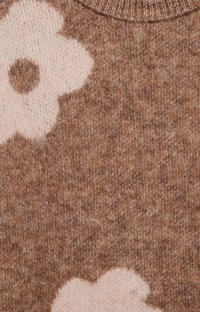 Brown knitted fabric featuring a large cream floral pattern. The texture appears soft with a mix of light and dark brown fibers.