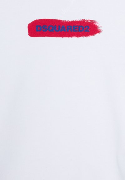 T-shirt bianca con un grafico a pennellate rosse e la scritta "DSQUARED2" stampata in blu. Materiale cotone, texture liscia, design casual.