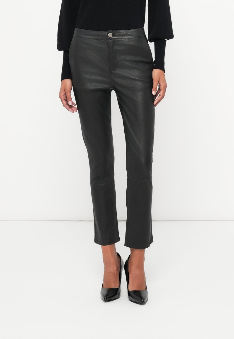 Čierne, syntetické kožené nohavice slim fit s vysokým pásom, minimalistickými prednými detailmi a skráteným lemom, doplnené čiernymi vysokými podpätkami.