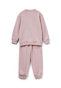 Różowy dres składający się z bluzy i spodni dresowych, z prążkowanymi mankietami i dekoltem oraz tylną kieszenią w spodniach. Miękka tekstura.