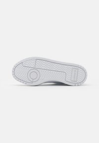 Weiße Sneaker-Sohle mit strukturierten Rillen und Erhöhungen. Rundes Emblem in der Mitte, Branding in der Nähe der Ferse. Glattes, langlebiges Gummi-Material.