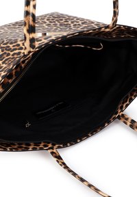 Bolsa tote con estampado de leopardo, forro interior de tela negra, cierre con cremallera y bolsillo interior. Cuenta con asas dobles y textura suave.