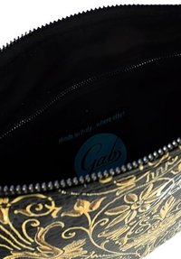 Borsetta in pelle nera con embossing floreale dorato, chiusura con zip e interno liscio. Presenta l'etichetta "Gabs" all'interno.