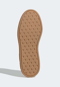 Skosula med gumminnasmaterial och ett texturerat diamantmönster för grepp, omgiven av en slät kant och rundad form.