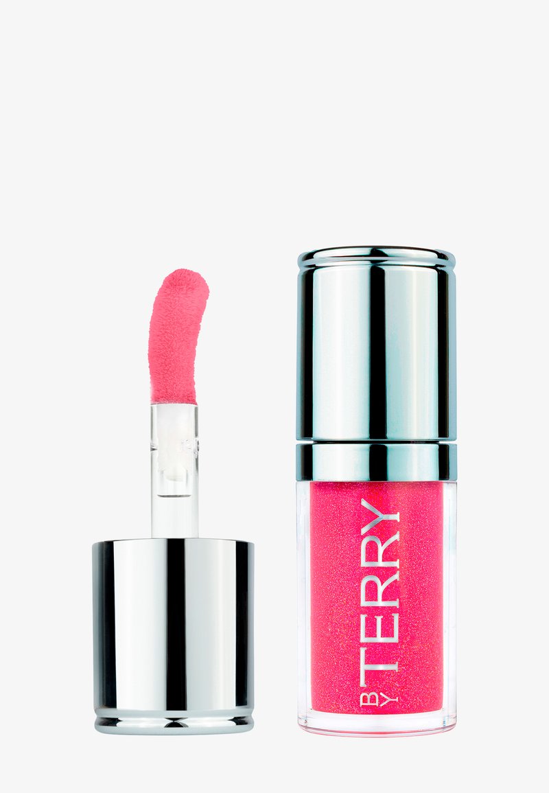 Gloss à lèvres pailleté rose dans un tube transparent avec un capuchon argenté, applicateur retiré montrant une pointe douce et inclinée.