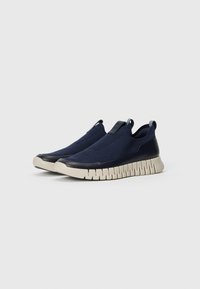 Blue slip-on sneakers with textured fabric upper, cushioned sole, and a contrasting beige rubber outsole. Minimalist design, no visible laces.