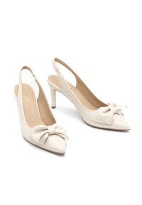 White leather slingback heels with a pointed toe, featuring a decorative bow on the vamp and a slim, mid-height heel. Smooth texture.