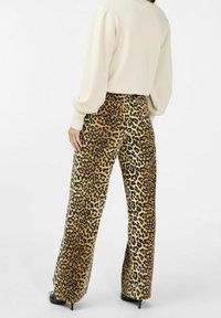 Pantalones de pierna ancha en estampado de leopardo en marrón, beige y negro. Confeccionados en una tela suave con una textura lisa, presentan una cintura de altura media y un ligero acampanado.