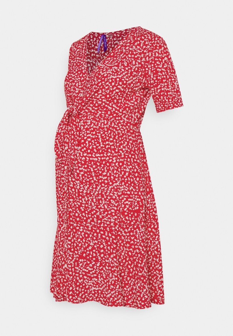 Robe de maternité rouge avec motif floral blanc, manches courtes, col en V et détail de ceinture à la taille sur fond uni.