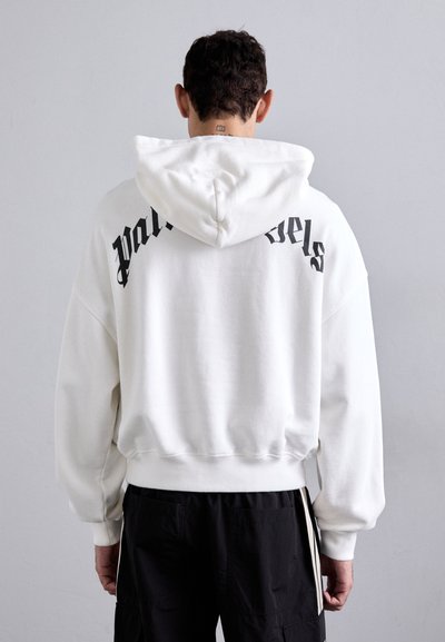 Sudadera blanca con capucha y texto negro "Palm Angels" en la parte posterior. Presenta un corte relajado, puños acanalados y una tela suave y texturizada.