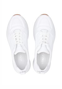 Weiße Sportschuhe mit einem strukturierten Stoff-Obermaterial, kreisförmigen Perforationen, flachen Schnürsenkeln und einer Gummisohle mit einem kontrastierenden Fersenlasche.