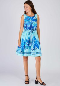 Blumenkleid im A-Linien-Stil in Hellblau mit blauen Blumen, einem taillierten Oberteil und einer gebundenen Taille. Verfügt über einen gemusterten Saum und ein ärmelloses Design.