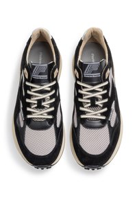 Sneaker neri e grigi realizzati in materiali scamosciati e in rete, con lacci ben visibili, suole imbottite, logo sulla linguetta e dettagli testurizzati.