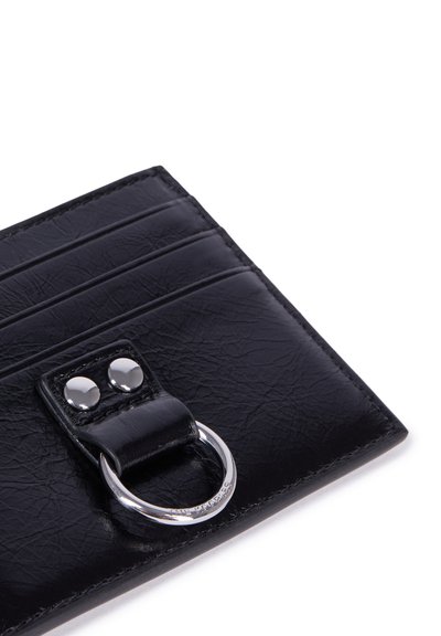 Zwarte leren portemonnee met een gestructureerde afwerking, voorzien van vijf kaartsleuven en een metalen ringaccent. Zilveren hardware bij de sluiting.