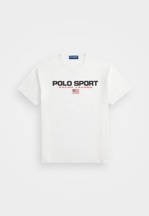 Biały t-shirt z krótkim rękawem z czarnym i czerwonym tekstem ""POLO SPORT RALPH LAUREN"" nad małą amerykańską flagą z przodu.